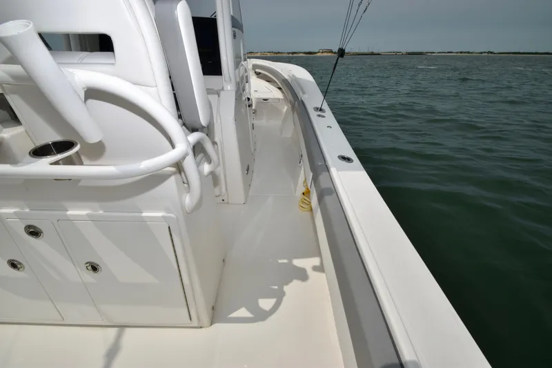 Slide: The Image of The image shows the deck of a 2023 Regulator 28 Forward Seating boat on calm water. - 41