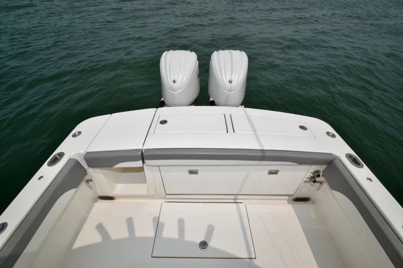 Slide: The Image of The image shows the stern of a Regulator 28 Forward Seating boat with two outboard engines. - 43