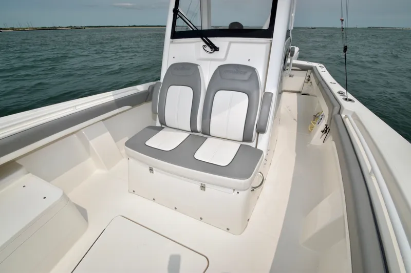 Slide: The Image of The image shows the seating area of a 2023 Regulator 28 Forward Seating boat on the water. - 23