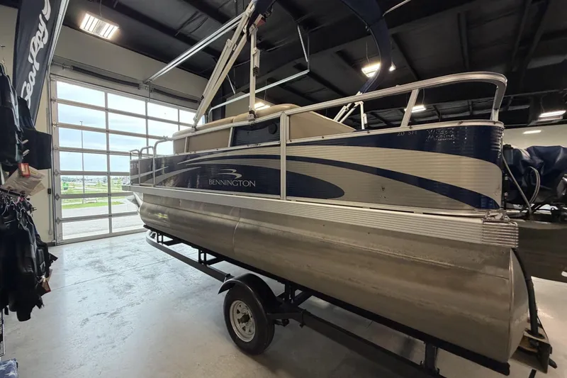 Slide: The Image of 2010 Bennington 20SFi pontoon boat displayed indoors on a trailer. - 6
