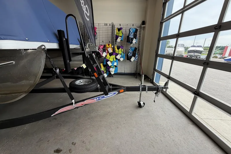 Slide: The Image of Boat trailer with Bennington 20SFi, life jackets displayed, garage setting, 2010 model. - 2