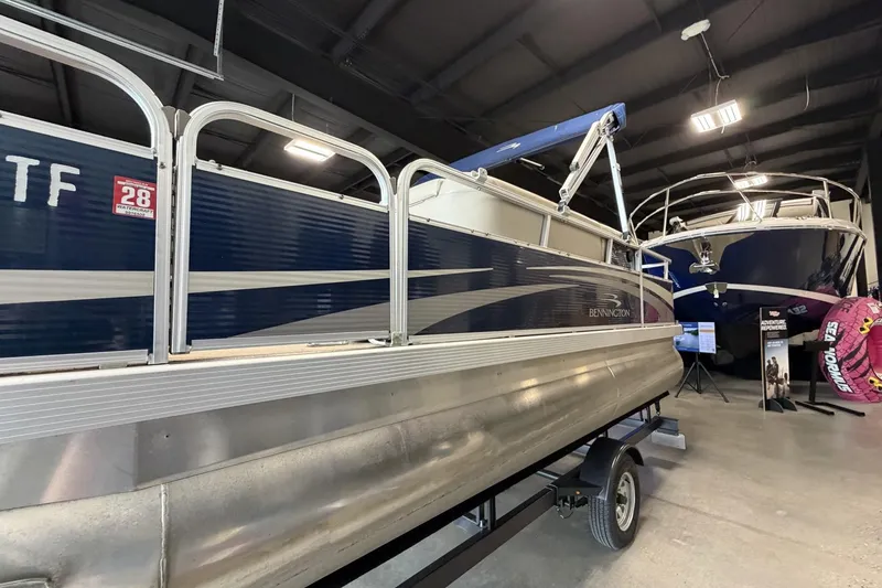 Slide: The Image of 2010 Bennington 20SFi pontoon boat displayed indoors on a trailer. - 7