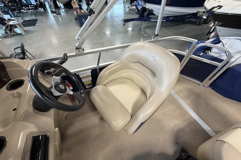 Slide: The Image of 2010 Bennington 20SFi boat interior with steering wheel and beige captain's chair. - 16