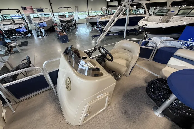 Slide: The Image of 2010 Bennington 20SFi pontoon boat interior at a showroom with other boats displayed. - 17