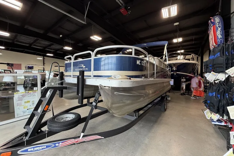 Slide: The Image of 2010 Bennington 20SFi pontoon boat displayed indoors on a trailer. - 9