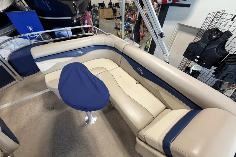 Slide: The Image of 2010 Bennington 20SFi boat interior with beige and blue seating, showroom display. - 12