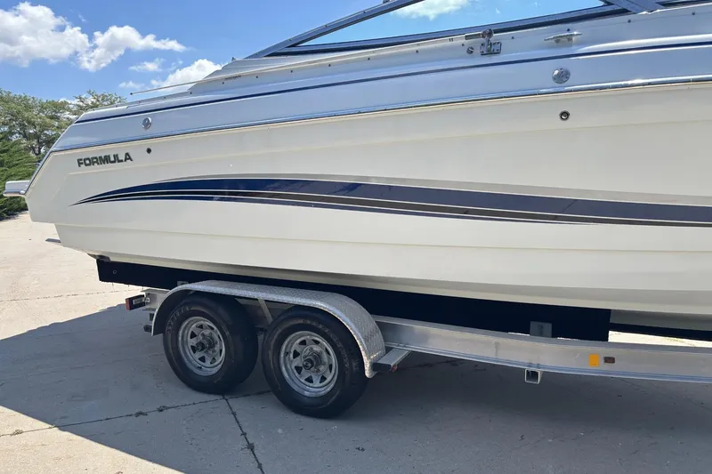 Slide: The Image of 2007 Formula 280 Bowrider boat on trailer, side view under clear blue sky. - 4