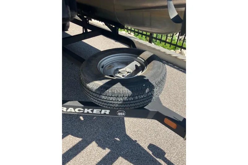 Slide: The Image of 2020 Sun Tracker Bass Buggy 18 DLX trailer with spare tire on asphalt. - 7
