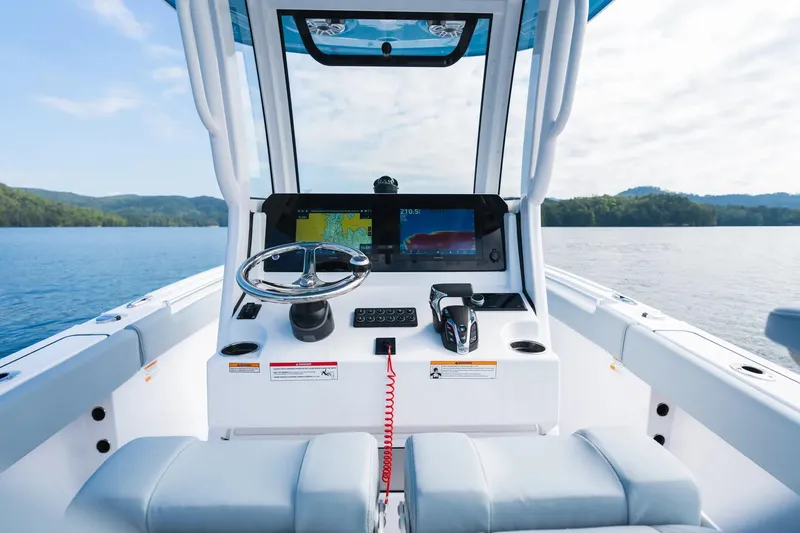 Slide: The Image of 2026 Sportsman Heritage 231 Center Console boat interior with steering wheel and navigation display. - 4