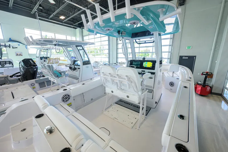 Slide: The Image of 2027 Sportsman Heritage 231 Center Console boat interior in showroom, featuring modern controls and seating. - 27