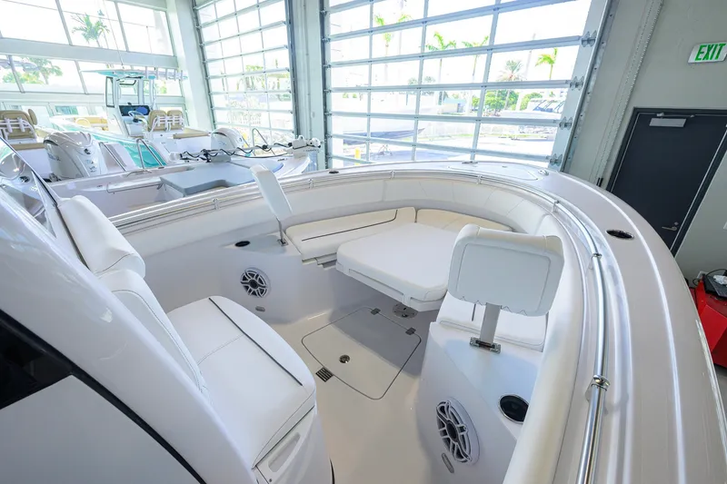 Slide: The Image of 2027 Sportsman Heritage 231 Center Console boat interior with white seating in a showroom. - 21