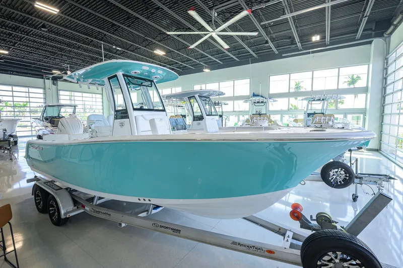 The Image of 2027 Sportsman Heritage 231 Center Console boat in showroom, turquoise hull, on trailer. - 0