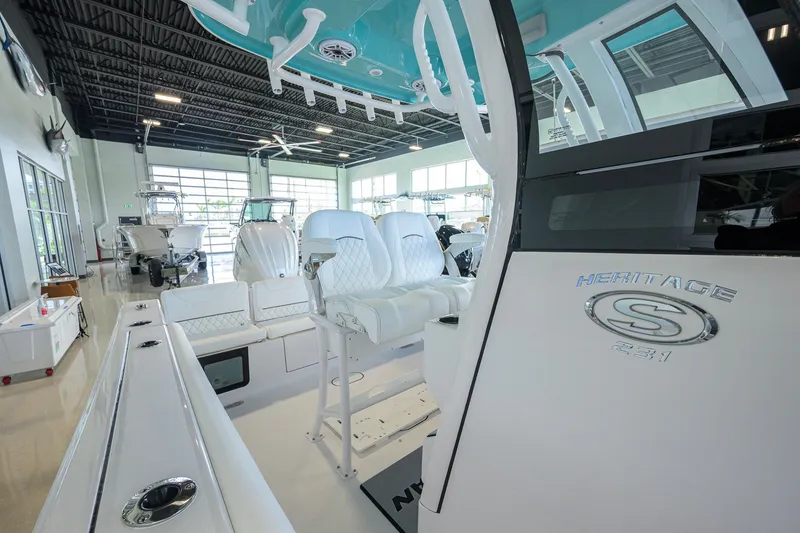 Slide: The Image of 2027 Sportsman Heritage 231 Center Console boat interior in showroom, featuring sleek seating and modern design. - 23