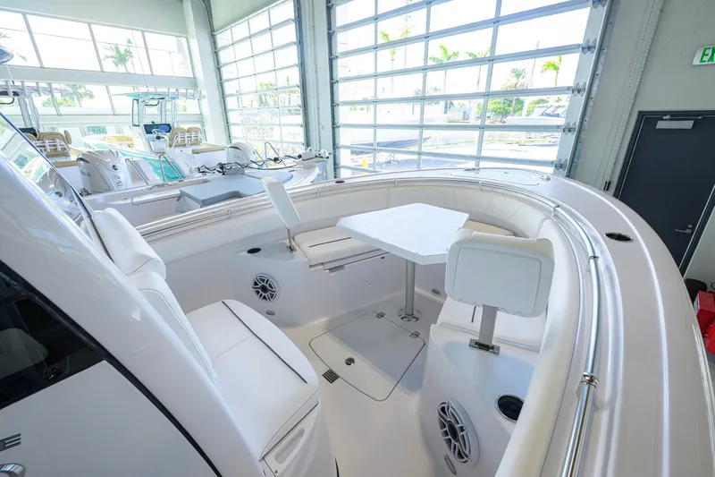 Slide: The Image of 2027 Sportsman Heritage 231 Center Console boat interior with seating and table in showroom. - 20