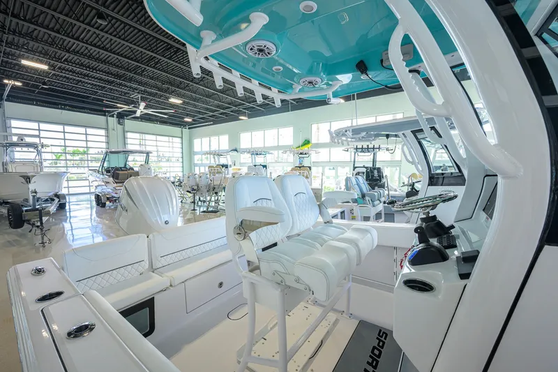 Slide: The Image of 2027 Sportsman Heritage 231 Center Console boat interior in showroom, featuring modern seating and controls. - 24