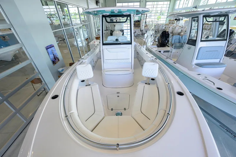 Slide: The Image of 2027 Sportsman Heritage 231 Center Console boat interior in showroom, featuring sleek seating and modern design. - 25