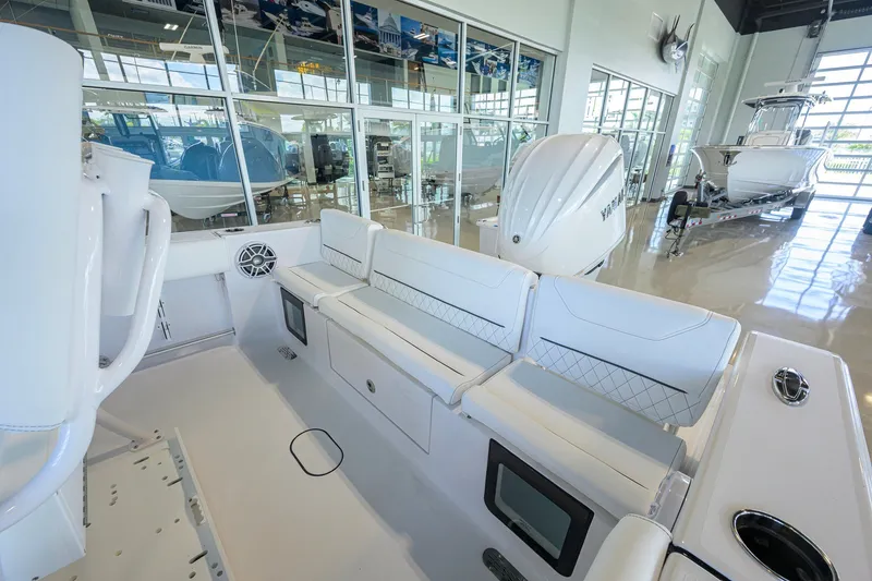 Slide: The Image of 2027 Sportsman Heritage 231 Center Console boat interior in showroom, featuring sleek seating and modern design. - 33