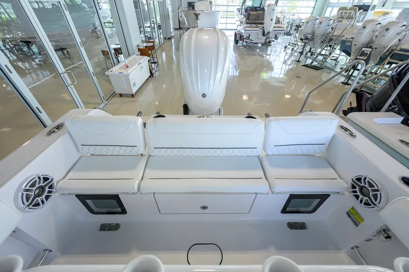 Slide: The Image of 2027 Sportsman Heritage 231 Center Console boat interior with white seating and speakers. - 31