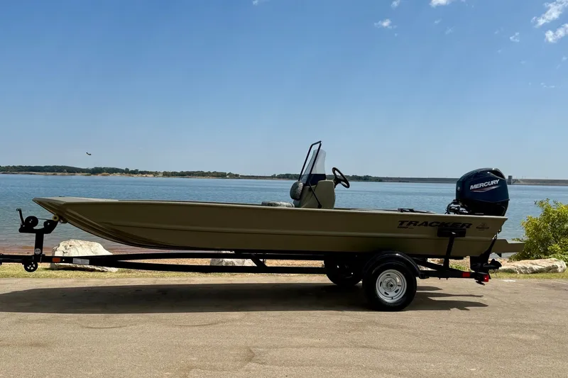 Slide: The Image of 2026 Tracker Grizzly 1860 CC boat on trailer by a serene lake. - 16