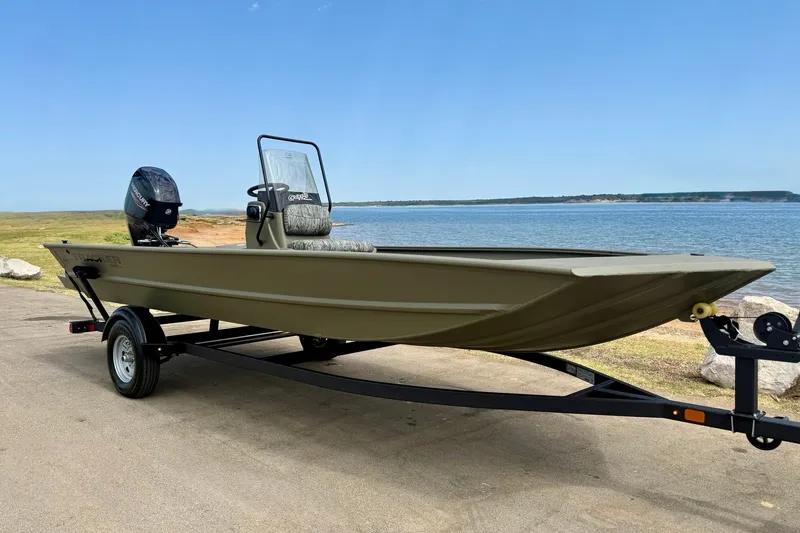 The Image of 2026 Tracker Grizzly 1860 CC boat on trailer by a lake. - 0