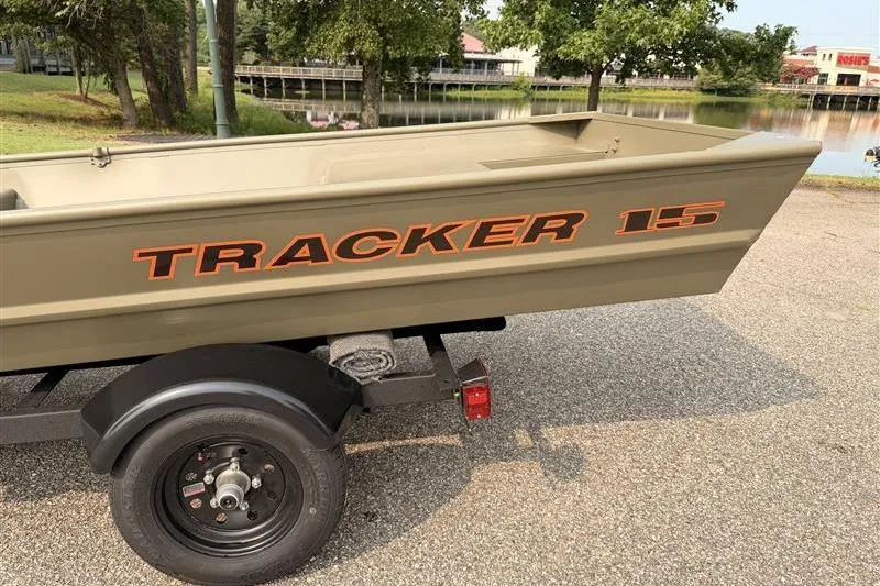 Slide: The Image of 2026 Tracker Grizzly 15 Jon boat on trailer near a scenic lake. - 5