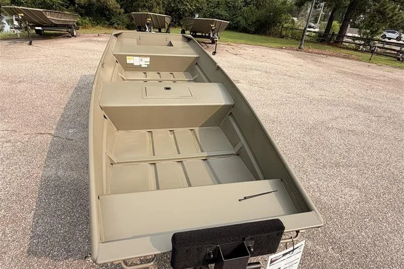 Slide: The Image of 2026 Tracker Grizzly 15 Jon boat on pavement, surrounded by trees and trailers. - 6