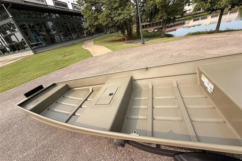 Slide: The Image of 2026 Tracker Grizzly 15 Jon boat on display near a scenic pond. - 10