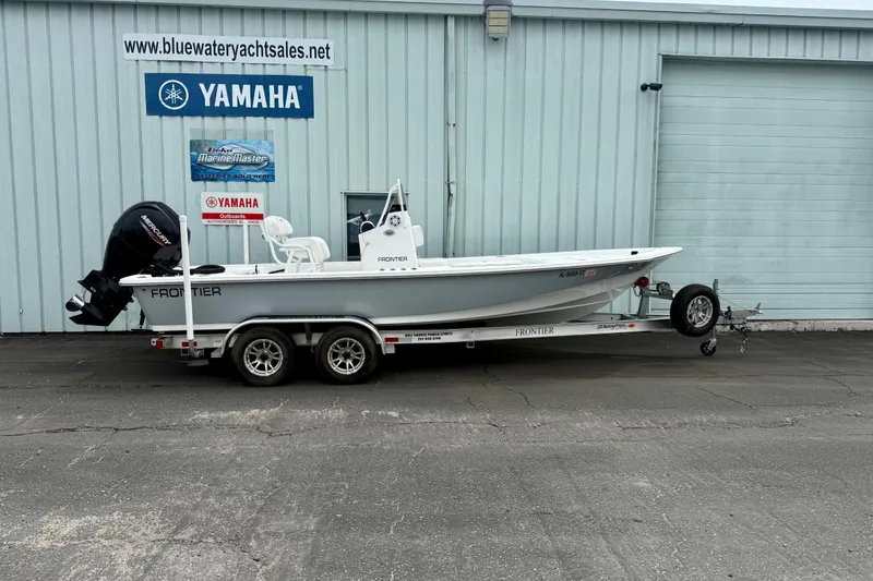 Slide: The Image of 2023 Frontier 2104 boat on trailer outside dealership with Yamaha signage. - 1