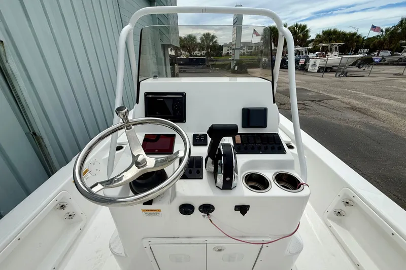Slide: The Image of 2023 Frontier 2104 boat console with steering wheel, controls, and navigation equipment. - 11