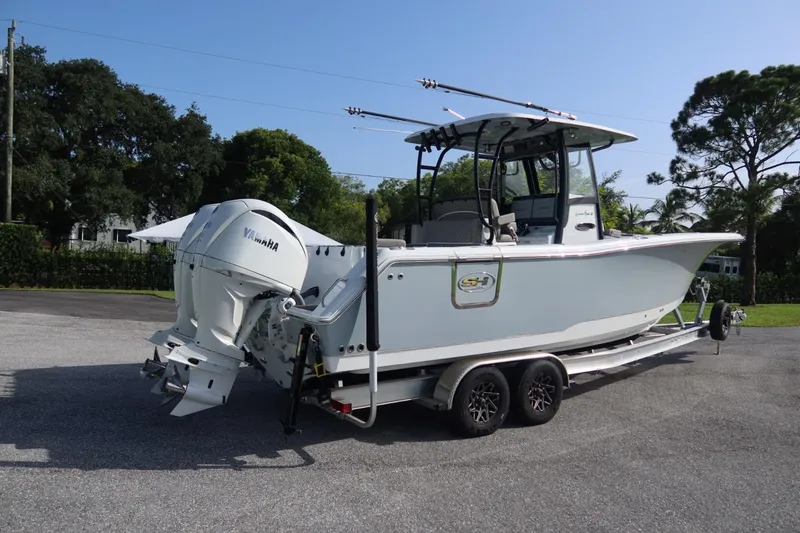 Slide: The Image of 2025 Sea Hunt Gamefish 28 Coffin Box boat on trailer, featuring dual Yamaha engines. - 1