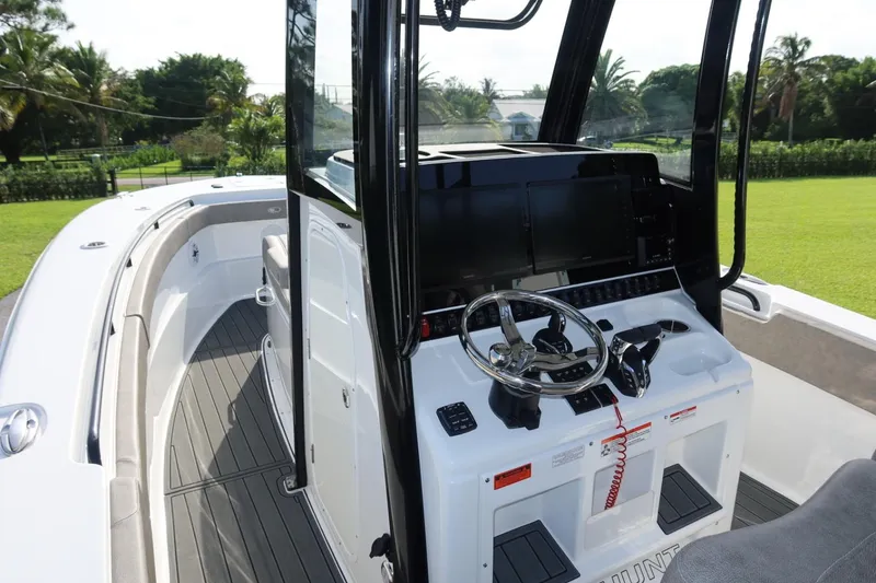 Slide: The Image of 2025 Sea Hunt Gamefish 28 Coffin Box boat interior with steering console and seating. - 28