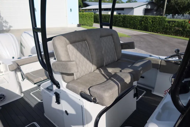 Slide: The Image of 2025 Sea Hunt Gamefish 28 Coffin Box boat interior with cushioned seating and steering console. - 23
