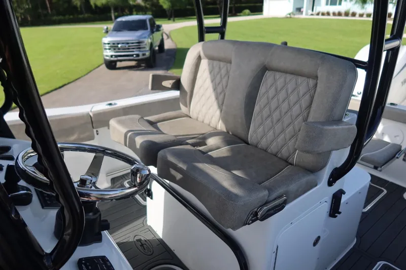 Slide: The Image of 2025 Sea Hunt Gamefish 28 Coffin Box boat interior with plush seating and steering wheel. - 24