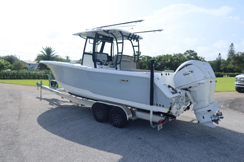 Slide: The Image of 2025 Sea Hunt Gamefish 28 Coffin Box boat on trailer, featuring Yamaha outboard engine. - 3