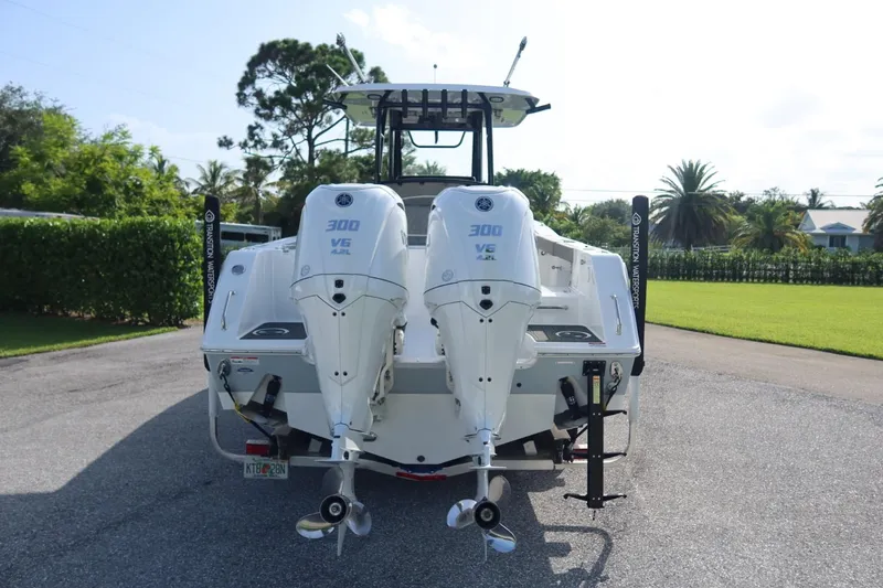 Slide: The Image of 2025 Sea Hunt Gamefish 28 Coffin Box with dual Yamaha 300 V6 engines, parked outdoors. - 2
