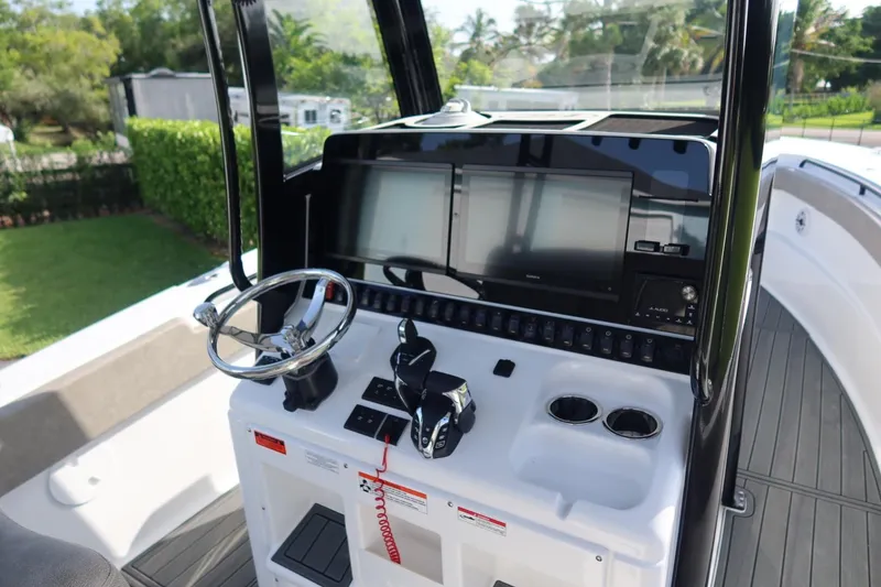 Slide: The Image of 2025 Sea Hunt Gamefish 28 Coffin Box helm with dual screens and steering wheel. - 21