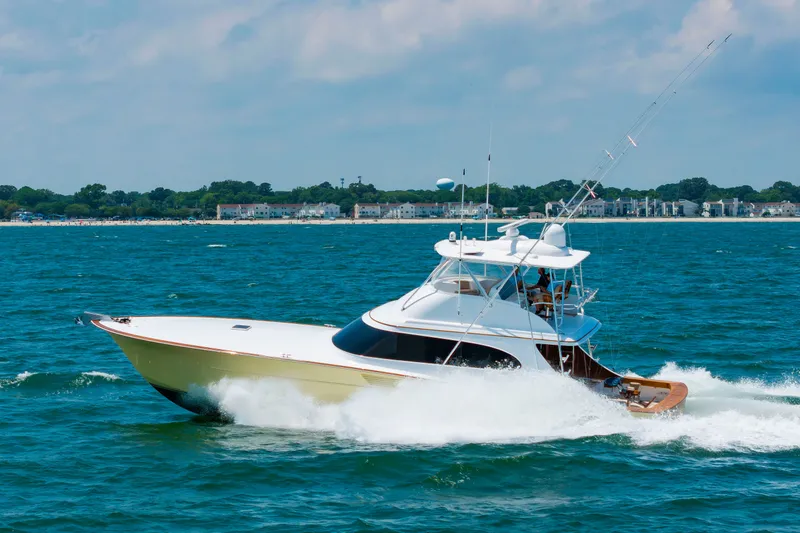 Slide: The Image of A 2022 Scarborough 63 speeds across blue waters, with a cityscape in the background. - 10