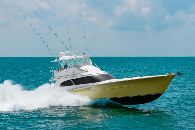 Slide: The Image of A 2022 Scarborough 63 speeds across the sea, featuring fishing rods and splashing water. - 9