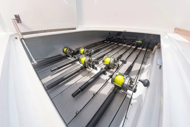 Slide: The Image of Fishing rods with reels are neatly arranged in a storage compartment on a boat. - 38