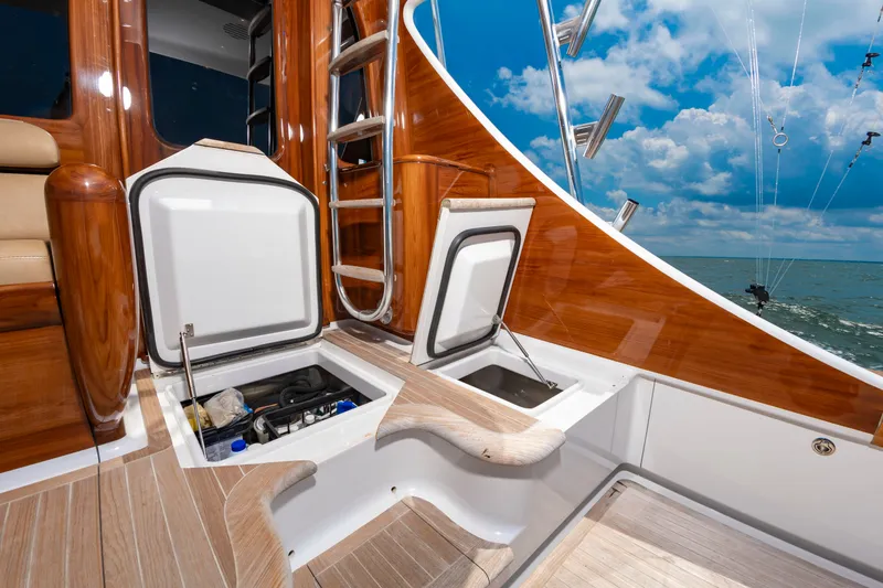 Slide: The Image of The image shows the deck of a 2022 Scarborough 63 with glossy wood and storage compartments. - 48