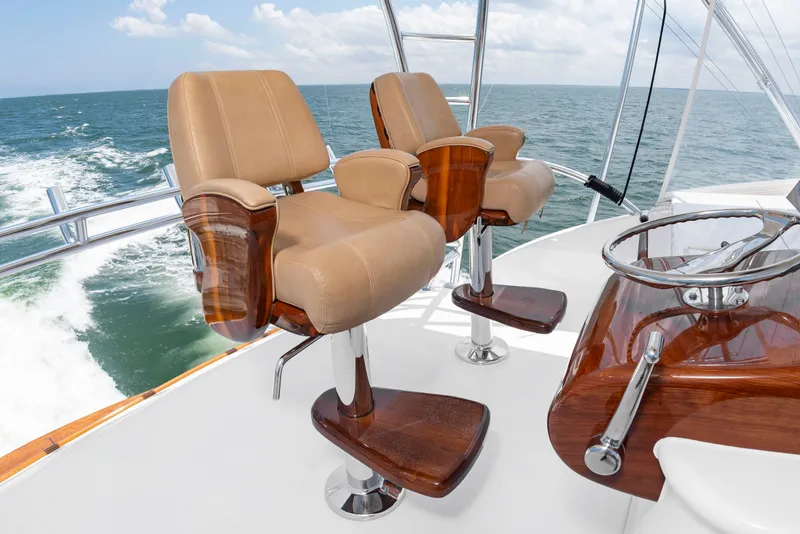 Slide: The Image of Two luxurious captain's chairs made of wood and leather on a boat overlooking the sea. - 30