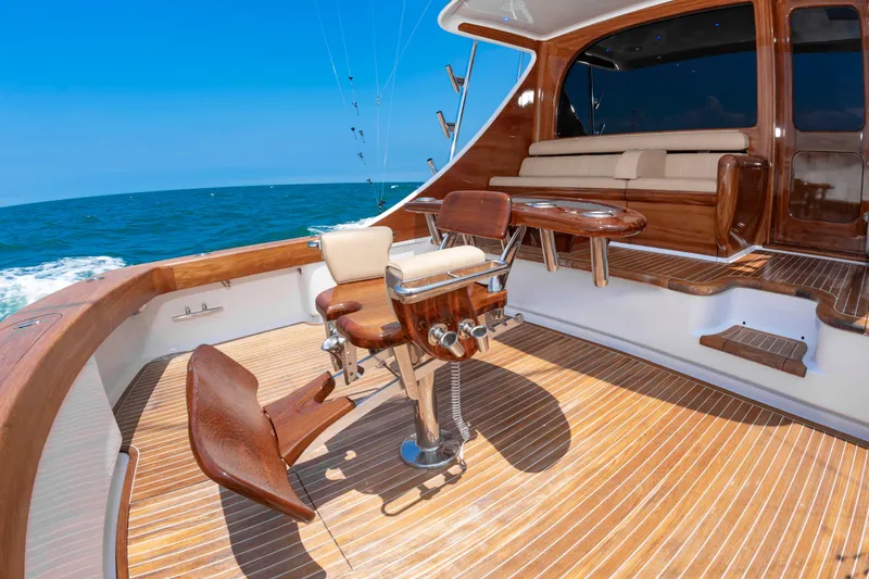 Slide: The Image of The image shows the deck of a 2022 Scarborough 63 with elegant wooden furniture and a blue sea backdrop. - 45