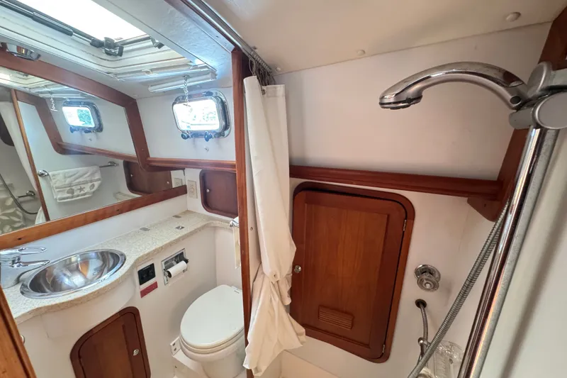 Slide: The Image of Compact 2002 Legacy Express boat bathroom with sink, toilet, and shower. - 58
