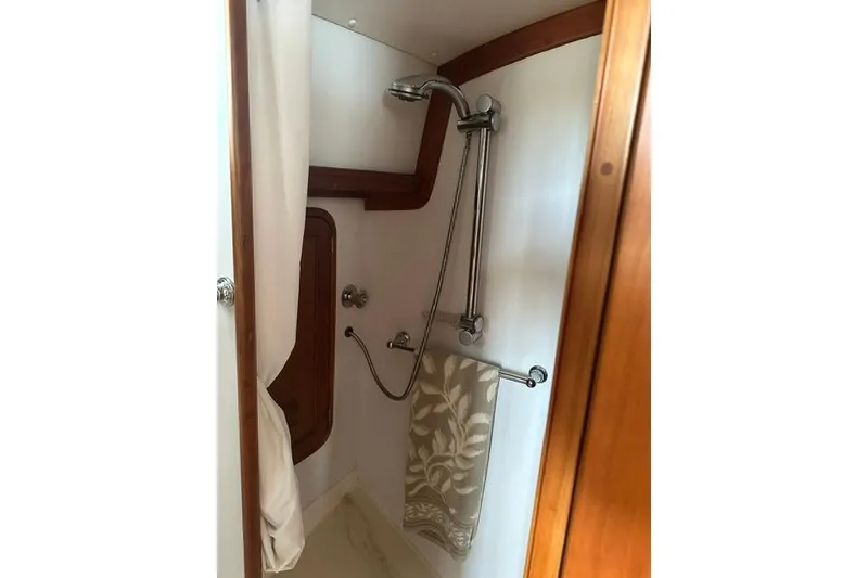 Slide: The Image of Shower area in 2002 Legacy Express boat with wooden accents and floral towel. - 24