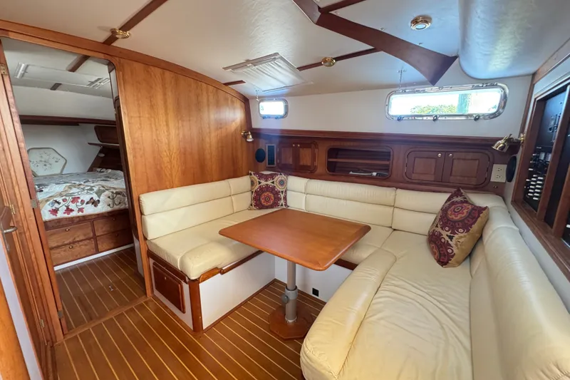 Slide: The Image of Cozy 2002 Legacy Express yacht interior with wood paneling and cushioned seating area. - 50