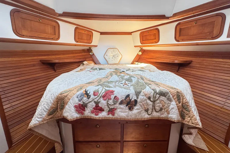 Slide: The Image of Cozy 2002 Legacy Express boat cabin with wooden interior and floral quilted bedding. - 45