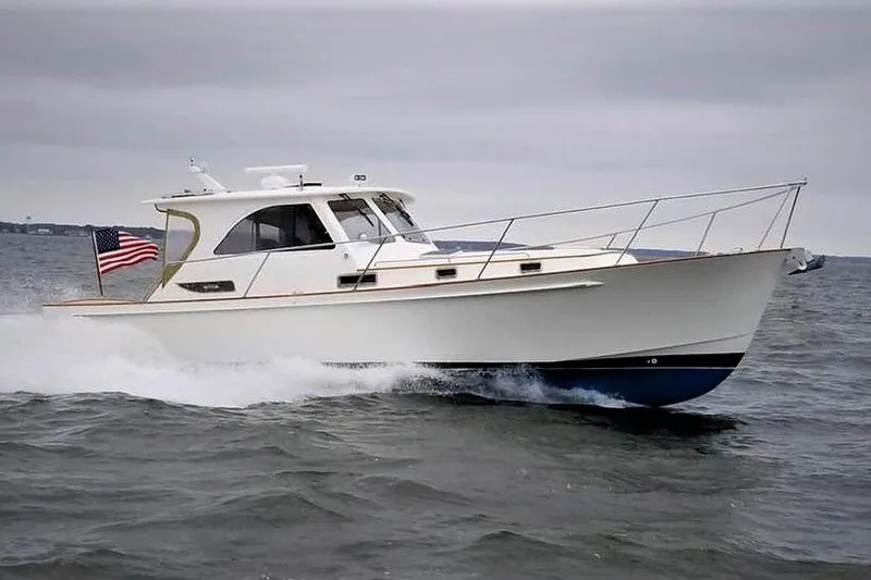 The Image of 2002 Legacy Express boat cruising on open water with American flag. - 0