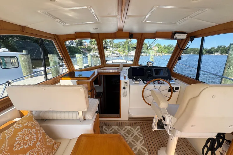 Slide: The Image of Interior of 2002 Legacy Express boat with helm, seating, and scenic water view. - 44