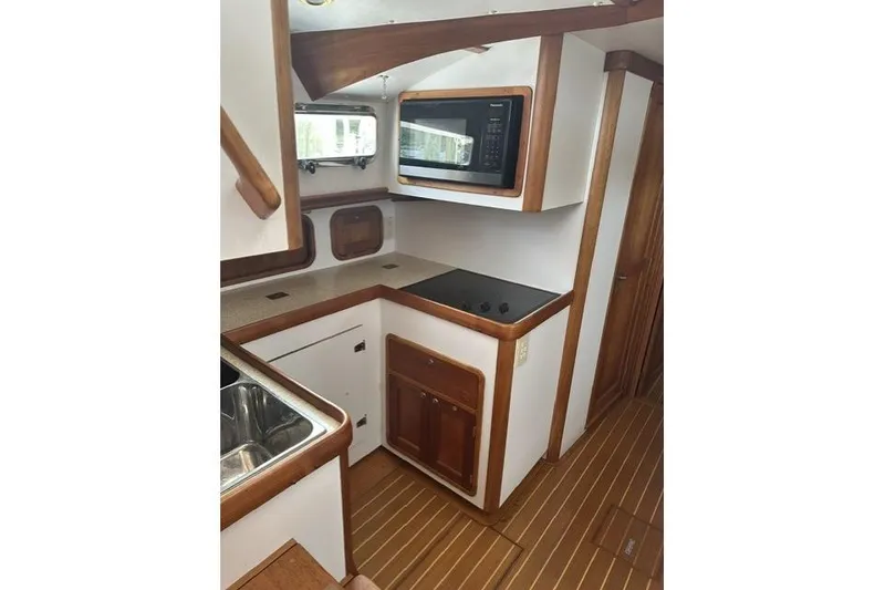 Slide: The Image of Compact kitchen in 2002 Legacy Express boat with wood accents and modern appliances. - 18
