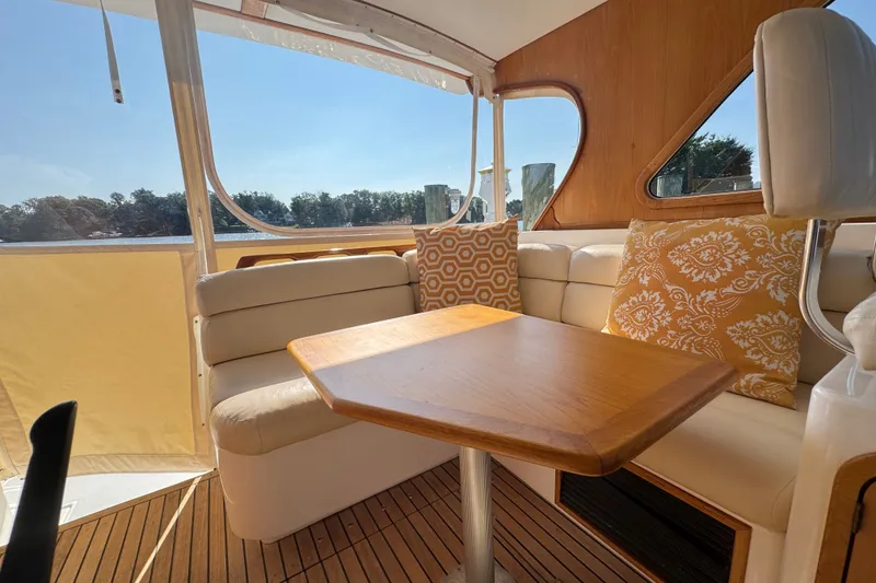 Slide: The Image of Cozy interior of 2002 Legacy Express boat with cushioned seating and decorative pillows. - 64